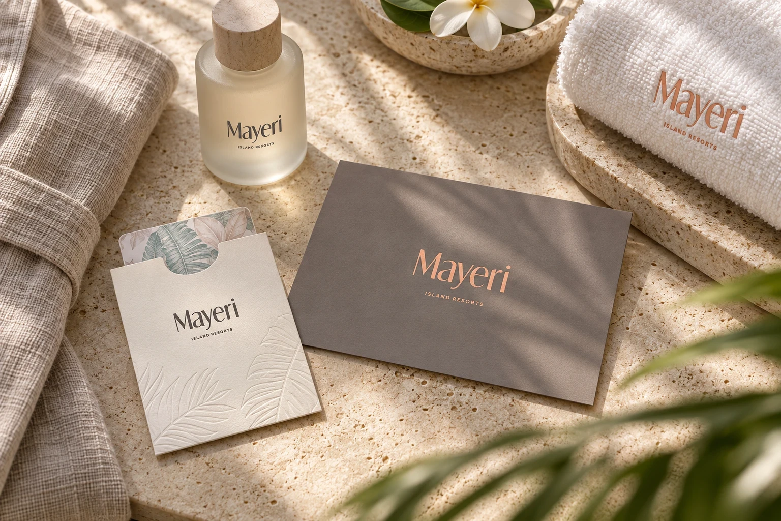 Papeterie et flacon Mayeri Island Resorts sur une surface claire, avec des fleurs blanches.