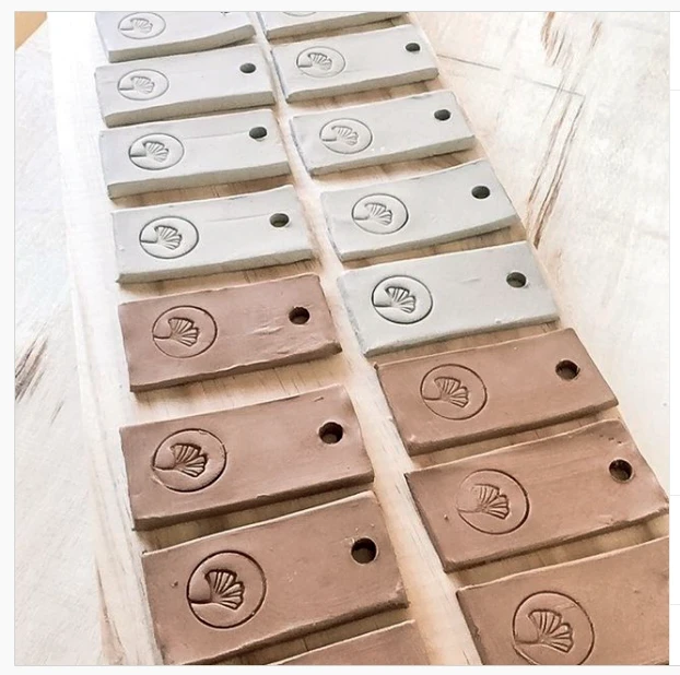 Plaquettes rectangulaires en argile claire et rose estampillées du symbole de feuille de Pigment It Pottery.