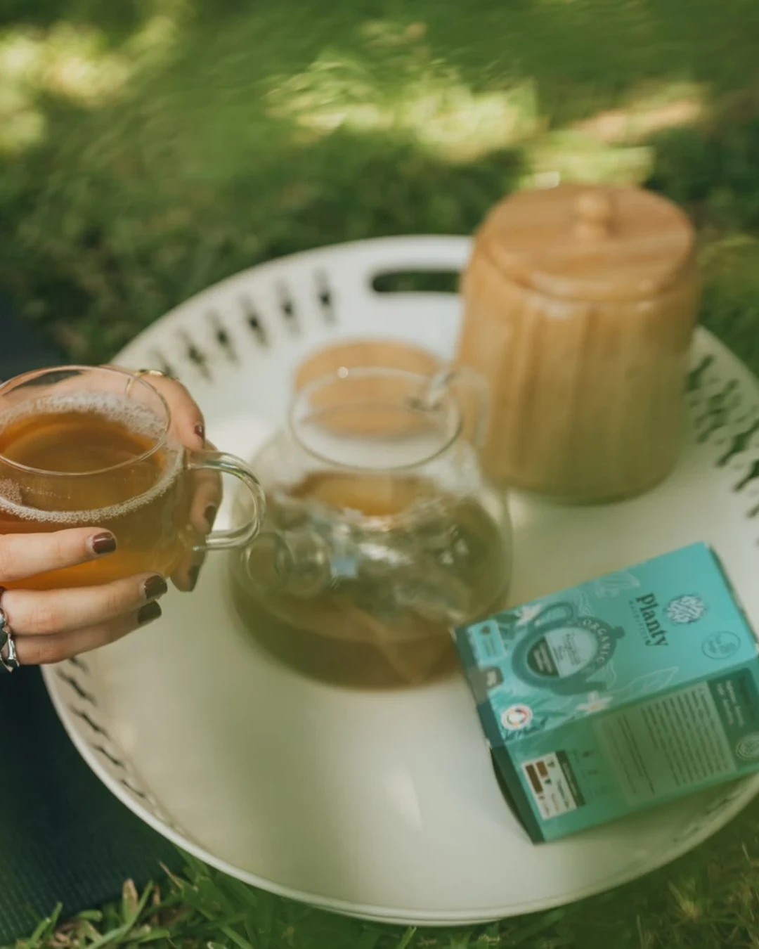 Deux tasses de thé et une boîte verte Corson autour d’une table.